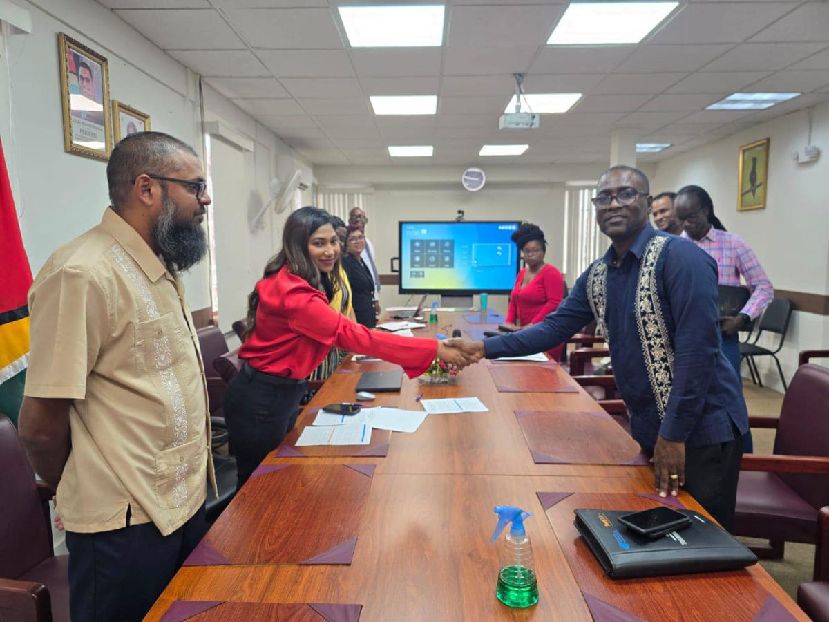  GTU President Mark Lyte and Permanent Secretary of the Ministry of Education Shanielle Hossein-Outar shake hands in the presence of Chief Education Officer Saddam Hussain and other union officials. (Ministry of Education photo)