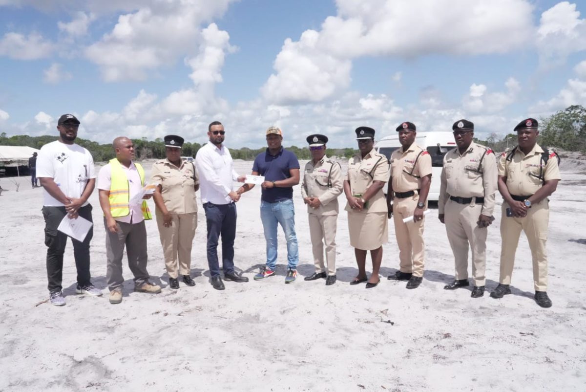 Permanent Secretary of the Ministry of Home Affairs, Andre Ally (fourth) from left) handing over one of the contracts (Police photo)