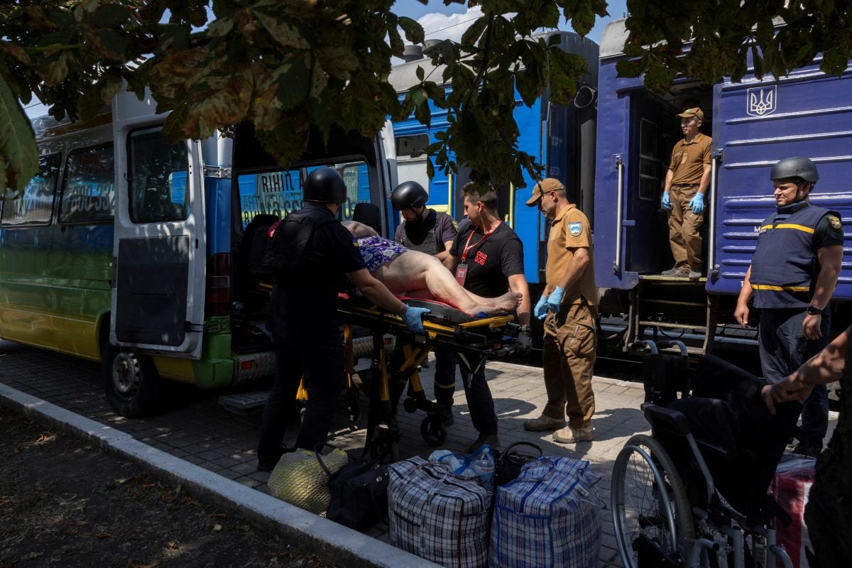 Volunteers of East SOS evacuate a woman, as Russian forces advance across the frontlines in the Donetsk region, at the train station in Pokrovsk, Ukraine, amid Russia’s attack on Ukraine, August 2, 2024.  REUTERS/Thomas Peter