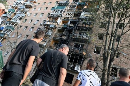 People gather in the courtyard of a multi-storey residential building, which according to local authorities was hit by debris from a destroyed Ukrainian missile, in the course of Russia-Ukraine conflict in Kursk, Russia August 11, 2024. Kommersant Photo/Anatoliy Zhdanov via REUTERS