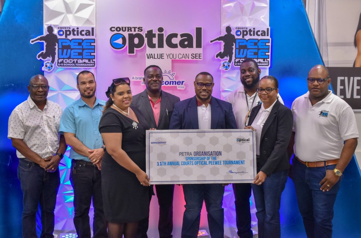 Petra Organisation Co-Director Troy Mendonca (centre front row)
receives the sponsorship cheque from Unicomer Head of Sales Malissa Sylvester
(second from right) while other members of Petra Organisation and Courts look on.