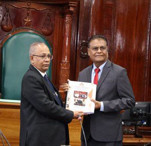 Auditor General, Deodat Sharma (left) handing over the Auditor General’s Report for the 2023 fiscal year to the Speaker of the National Assembly, Manzoor Nadir
