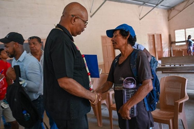 Minister of Public Works, Juan Edghill (left) engages a resident of Matthews Ridge, Region One (DPI photo)
