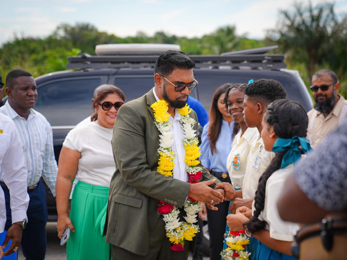 President Irfaan Ali (centre) being greeted on his arrival at Yarrowkabra. (Ministry of Education photo)
