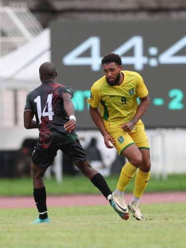 Guyana’s striker Deon Moore tries to evade the attention of a Martinique player during their 2-2 draw against the 10-man hosts. (Concacaf photo)