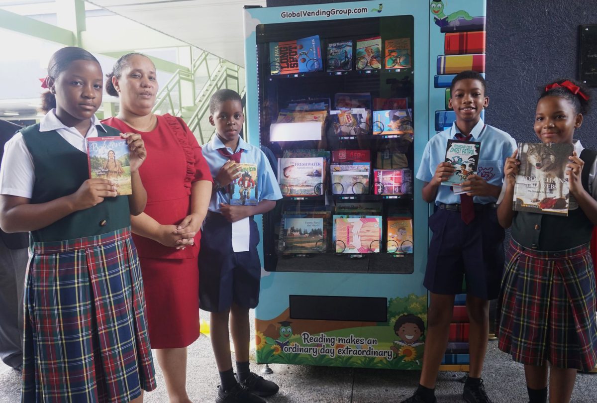 Minister in the Ministry of Education Lisa Morris-Julian with pupils of the San Juan Government Primary School at the school’s new book vending machine.