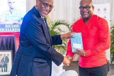 Governor General of Antigua & Barbuda, Sir Rodney Williams (left) receives a copy of the book, “Richie Richardson: The Man and the Legacy”, from its author Professor Densil Williams.