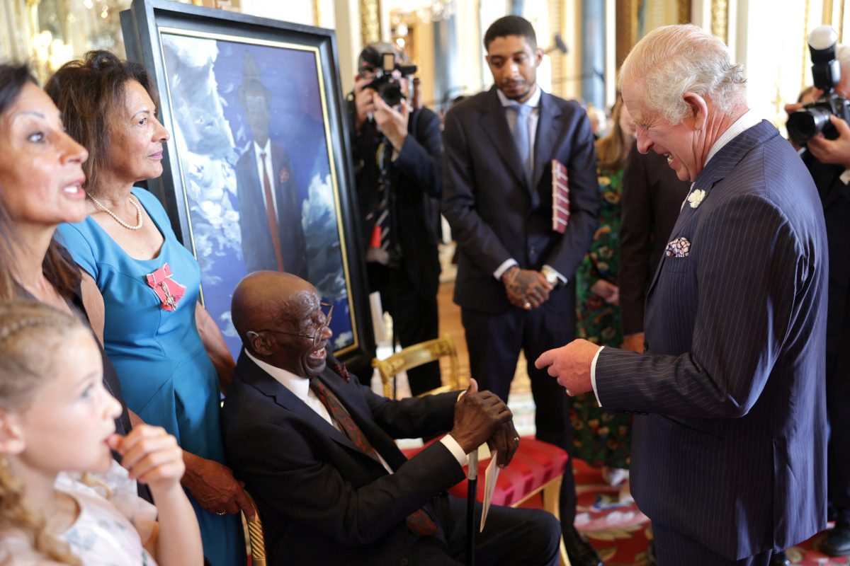 Britain’s King Charles laughing with Delisser Bernard during a reception to mark the 75th anniversary of the arrival of HMT Empire Windrush to British shores, at Buckingham Palace on June 14, 2023 in London, Britain. During the reception to celebrate the Windrush Generation, ten portraits of Windrush elders were unveiled.     Chris Jackson/Pool via REUTERS