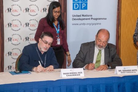 Chairman of the ERC, Shaikh Moeenul Hack (left) and UNDP Resident Representative for Guyana and Suriname, Gerardo Noto, signing the MoU (ERC photo)