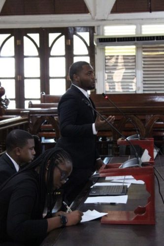 The winning team: Fabian Green - Senior Counsel (standing), Raheem Blair - Researcher (centre), and Juneeda Jeffers - Junior Counsel
