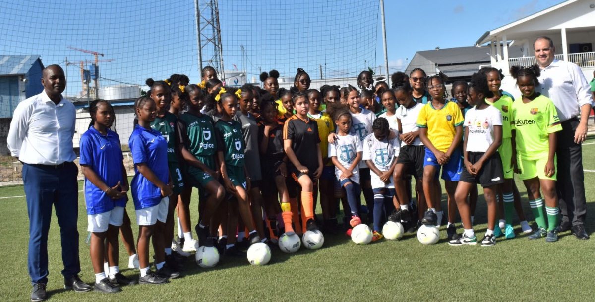 GFF President Wayne Forde (left) and Concacaf President Victor Montagliani (right) posed for a photo opportunity with some of the prospective participants in the Courts Girls U-13 Schools Football Championship at the NTC, Providence
