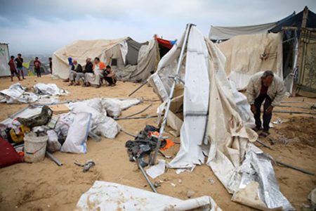 Palestinians inspect the damage at the site of an Israeli strike on a tent camp sheltering displaced people, amid the ongoing Israel-Hamas conflict, in Al-Mawasi area in Khan Younis, in the southern Gaza Strip, October 15, 2024.