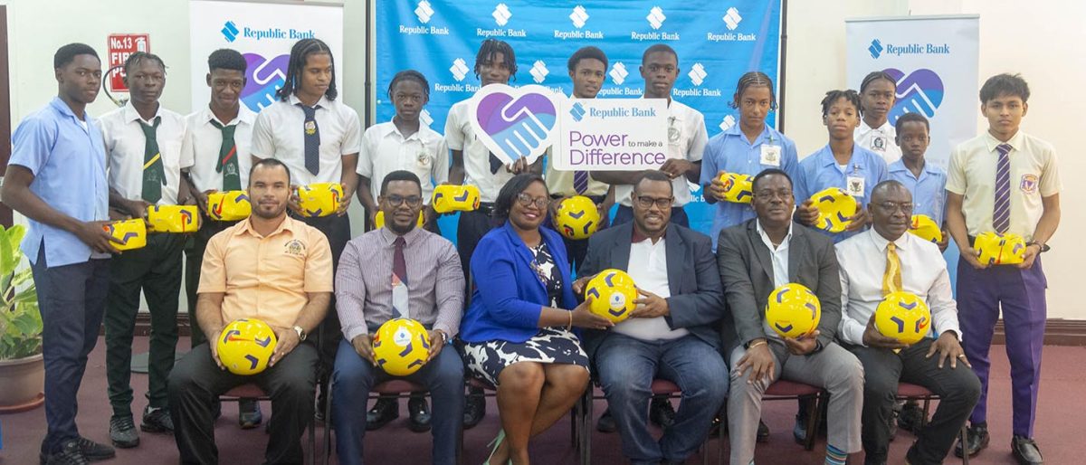 Some of the participating schools were on hand to collect their footballs to be used for training. Also in the photo are (sitting from left) Allied Arts Unit Head Nicholas Fraser, Republic Bank Internal Audit Manager Oral Rose, Republic Bank Marketing Manager Jonnel Dummett, Petra Organisation Co-Director Troy Mendonca, Assistant Director of Sport Franklin Wilson, and Petra Organisation representative Troy Peters. 
