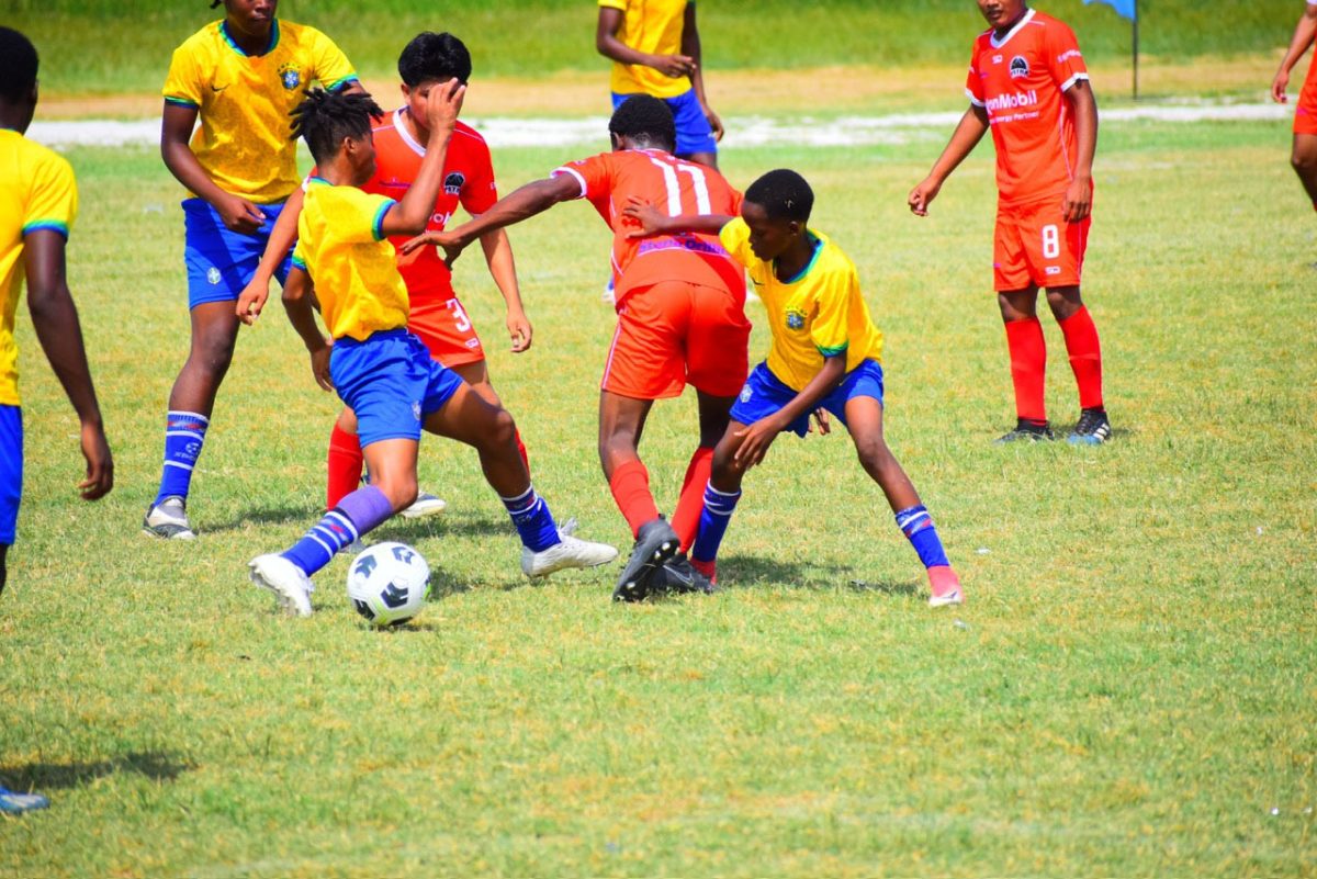 Part of the action between Bartica Secondary (orange) and East Ruimveldt in the opening encounter of the Republic Bank U-18 Schools Football League at the Ministry of Education Ground, Carifesta Avenue.
