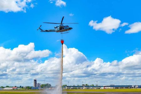  The Guyana Defence Force’s Bell 412 helicopter conducting an aerial firefighting demonstration during a training exercise yesterday. (Office of the President photo)