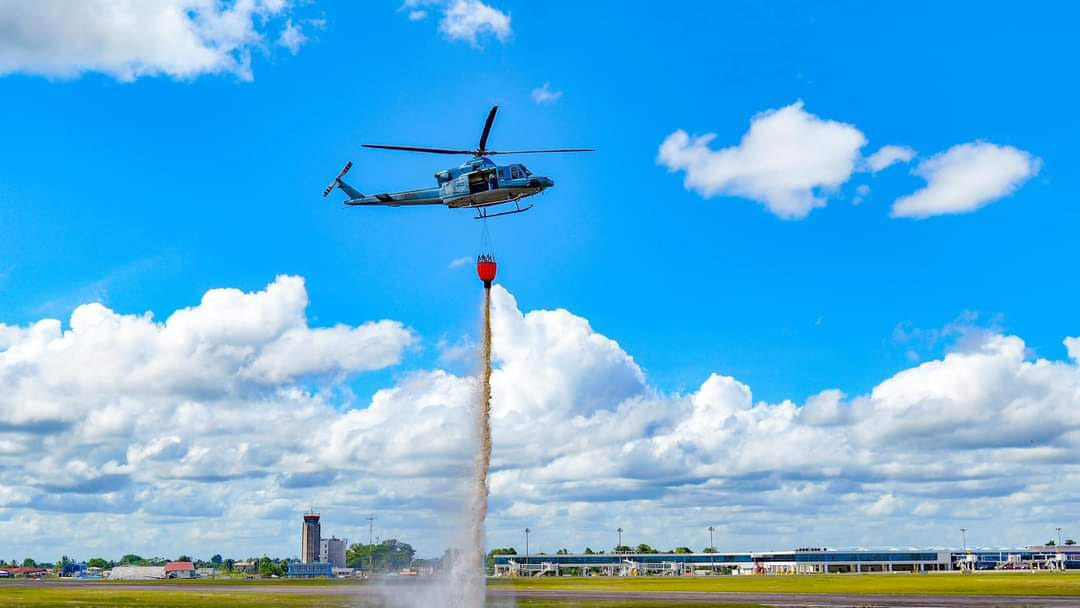  The Guyana Defence Force’s Bell 412 helicopter conducting an aerial firefighting demonstration during a training exercise yesterday. (Office of the President photo)