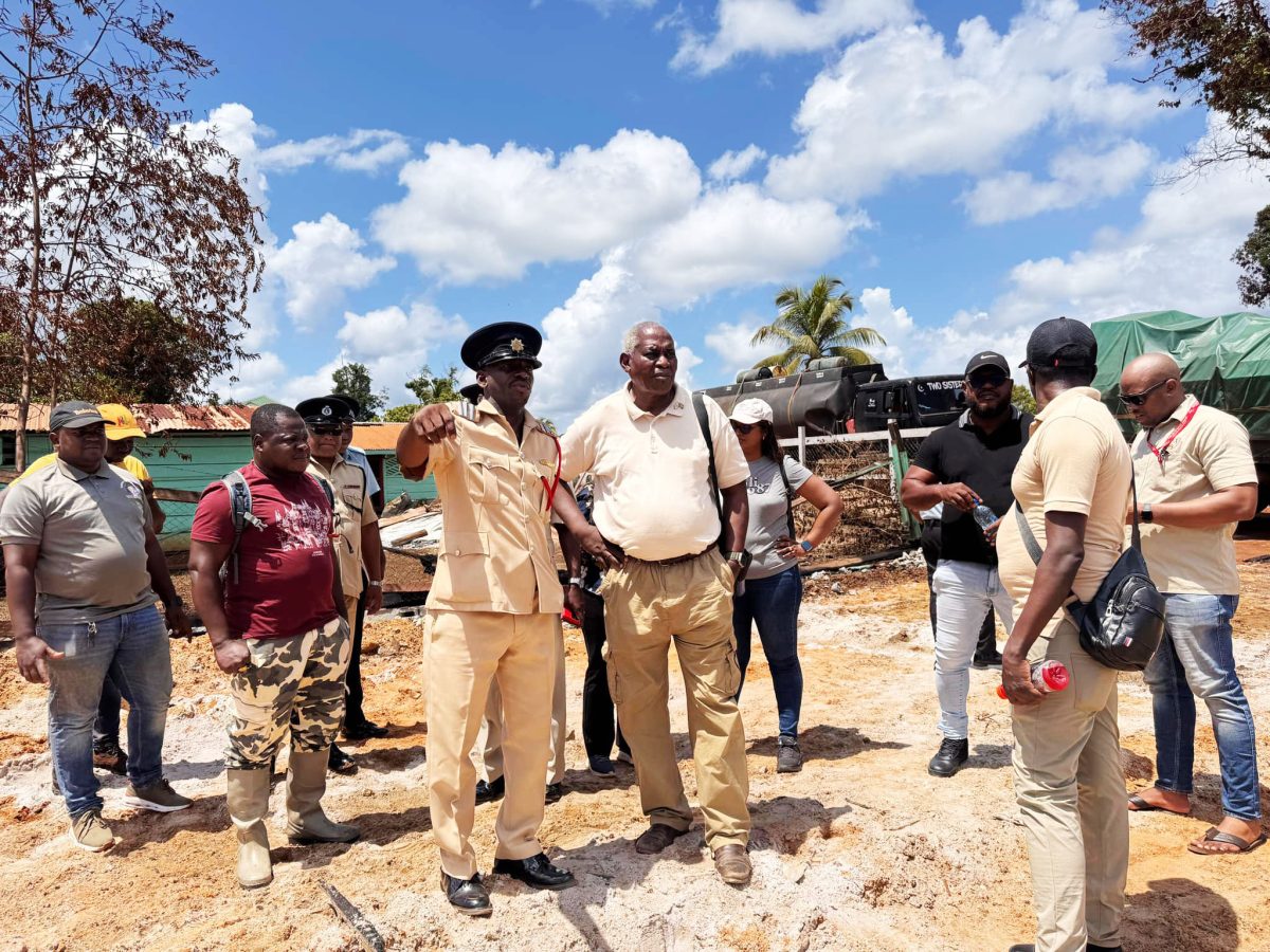 Minister of Home Affairs Robeson Benn, talks with Assistant Superintendent Doodnauth Chatram, a representative of the Guyana Fire Service, and residents among others
