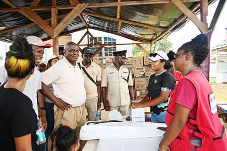 Minister of Home Affairs Robeson Benn, a representative of Red Cross, Regional Division #7 Commander, Dion Moore meeting with residents at Puruni Landing who suffered a recent fire. (Ministry of Home Affairs photo)
