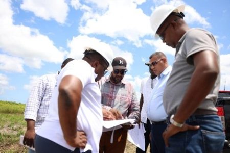 Minister of Housing and Water, Collin Croal conferring with officials at Golden Grove, East Bank Demerara