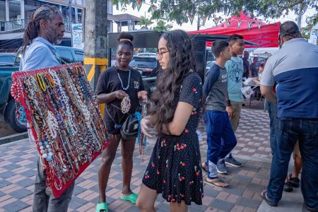 Difficult choice: This young woman had the difficult task of selecting a piece of hand made jewellery from a vendor at the recent Regional Food Festival on Main Street organised by the Ministry of Tourism, Industry and Commerce. (Ministry of Tourism, Industry and Commerce photo)