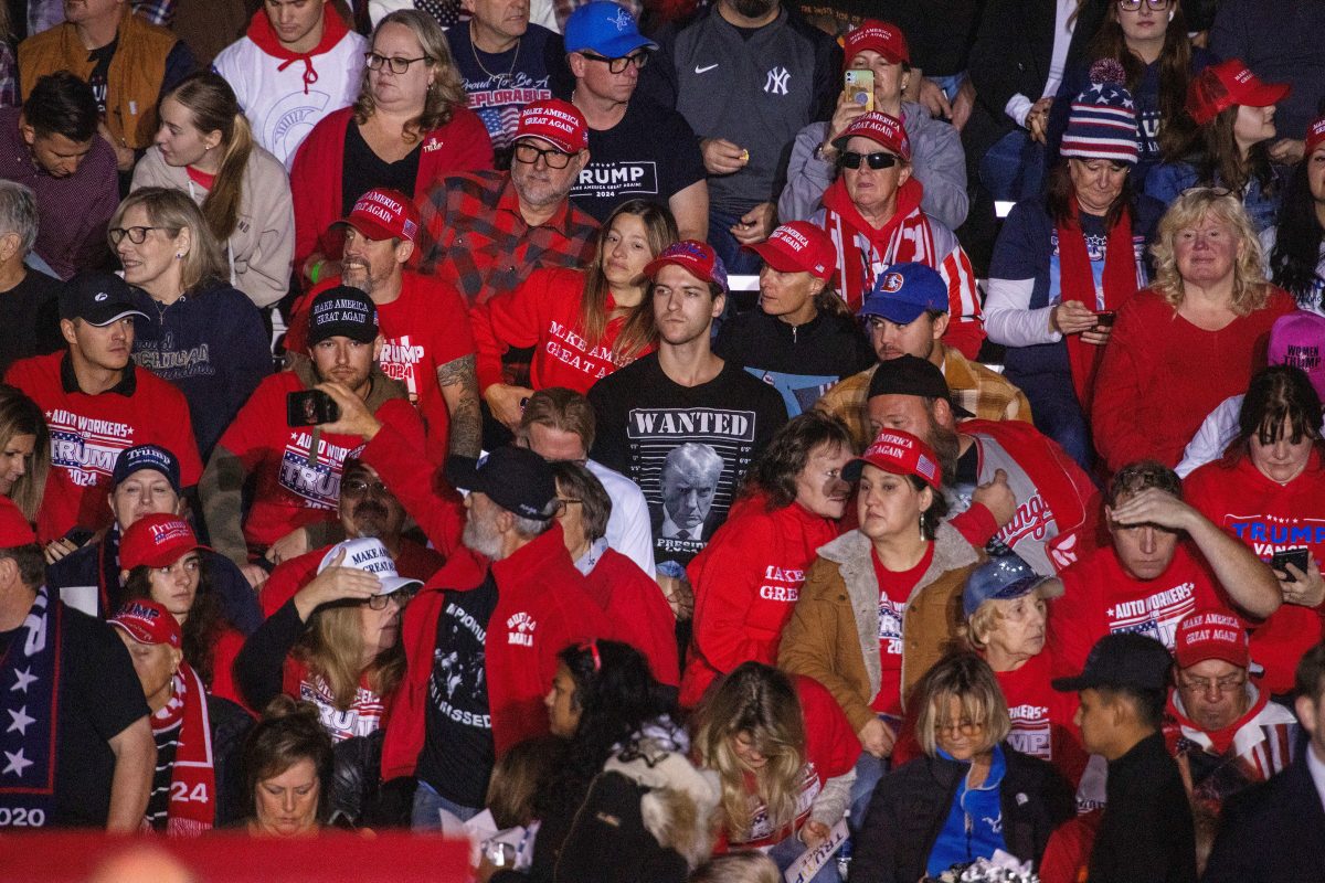 People wait for the start of a campaign rally of Republican presidential nominee and former U.S. President Donald Trump in Novi, Michigan, U.S., October 26, 2024. REUTERS/Carlos Osorio