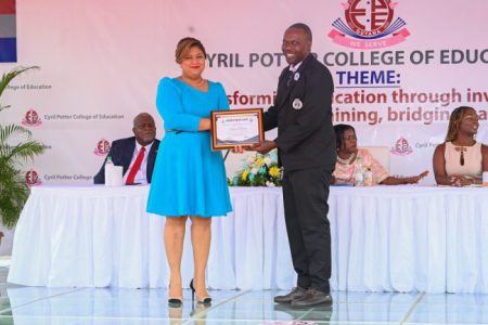 Minister of Education, Priya Manickchand, handing over an award to a graduate 