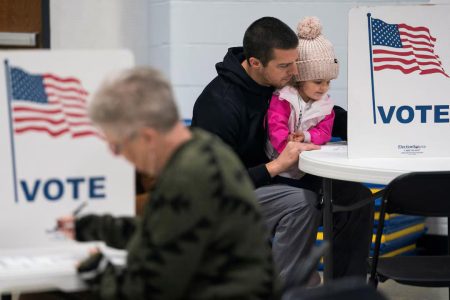 Dustin Ritchie, 34, votes with his daughter at the Douglas County Central Assembly of God polling location in Superior, Wisconsin.