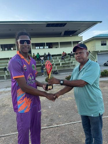 Young spinner Myheim Khan collects his man of the match award from a GCB official.
