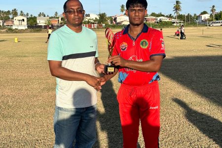 Asraf Ali Budhoo receives his man of the match award from BCB President Dr. Cecil Beharry.