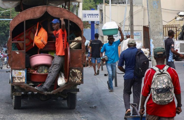 A man stands in the back of a truck full of belongings as residents flee the neighbourhood of Nazon due to gang violence, in Port-au-Prince, Haiti November 14, 2024. REUTERS/Marckinson Pierre