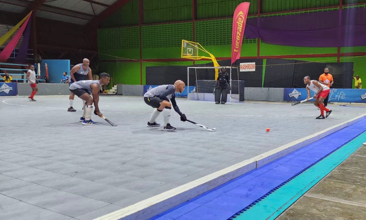 Omar Hopkinson (right) of Old Fort is trying to engineer an offensive play against T&T Police.