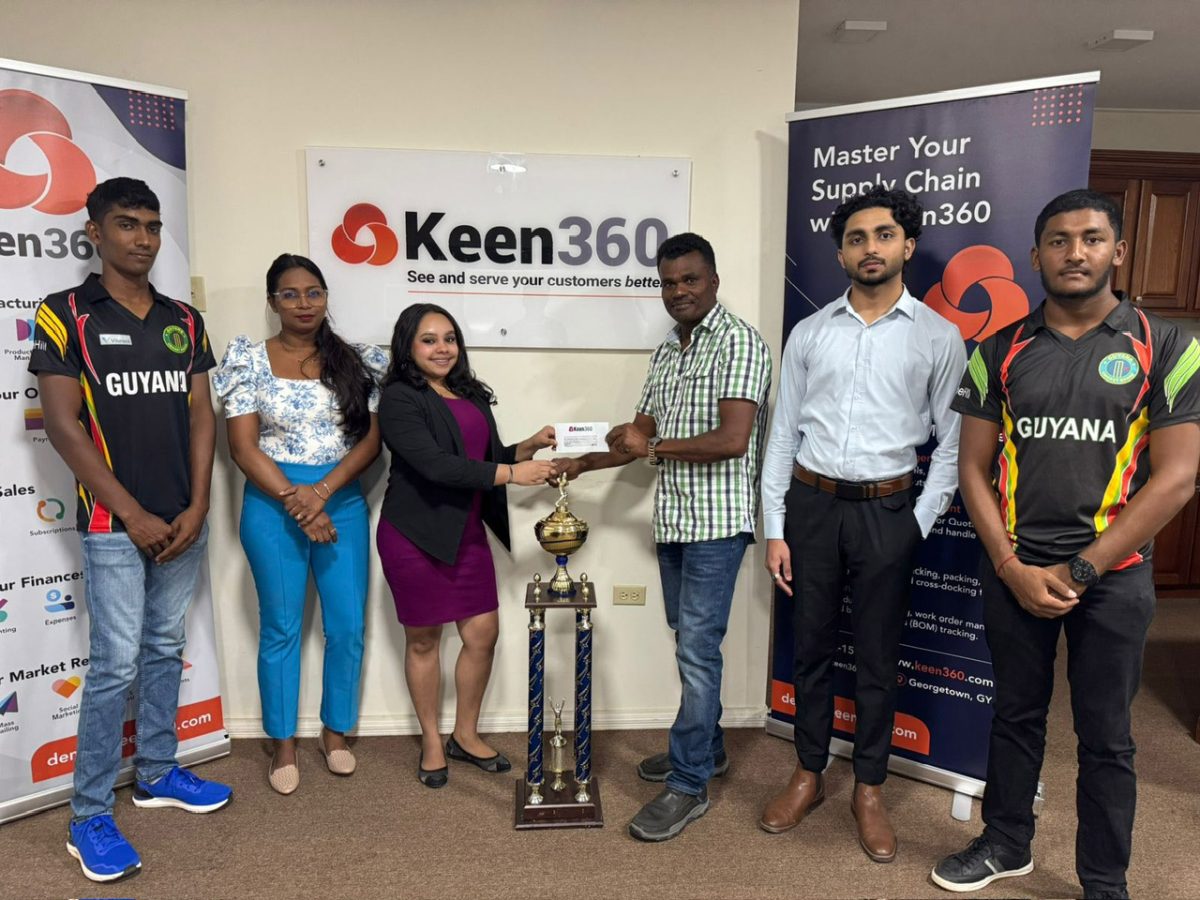 WDFA President Troy Khan receives the sponsorship from Keen360 representative Christine Bacchus in the presence of company officials and players