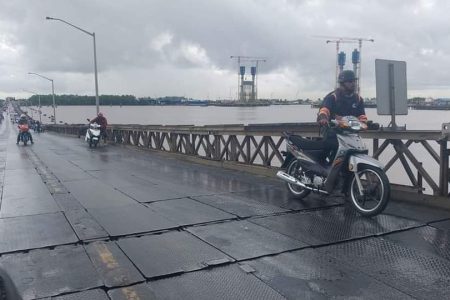 Commuters taking precautions crossing the bridge (Guyana Police Force photo)