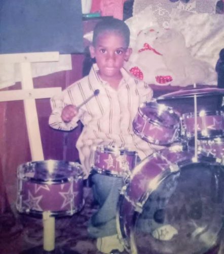 A young Jaheim Jones playing the drums in church
