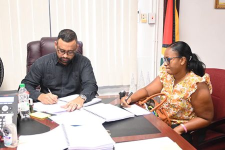 The signing of one of the contracts. Andre Ally is at left
(Ministry of Home Affairs photo)