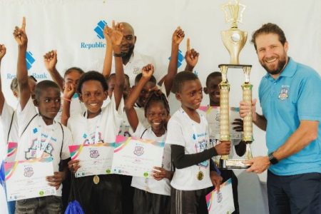 Republic Bank (Guyana) Ltd Managing Director, Stephen Grell, handing over the trophy to St. Theresa’s Primary who emerged victorious in the Republic Bank-sponsored “Five for Fun” competition
