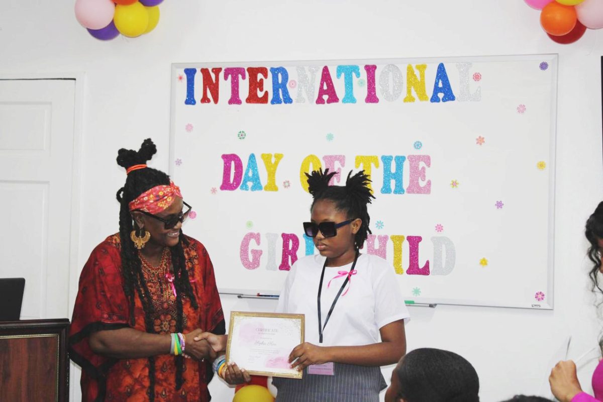 Sophia Kerr (right) receiving a certificate from Commissioner
Nicole Cole on International Day of the Girl Child 