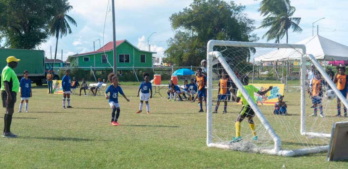 Defending champion Marian Academy (blue) scores from the penalty spot during their quarterfinal encounter with Smith Memorial.