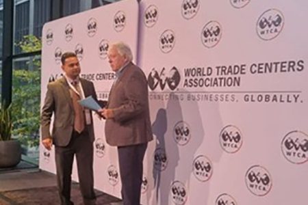 World Trade Center Georgetown Finance Director, Vasudeo Singh (left) presents a summary of the copyright study to World Trade Centers Association Chairman John Drew at the forum in New York 