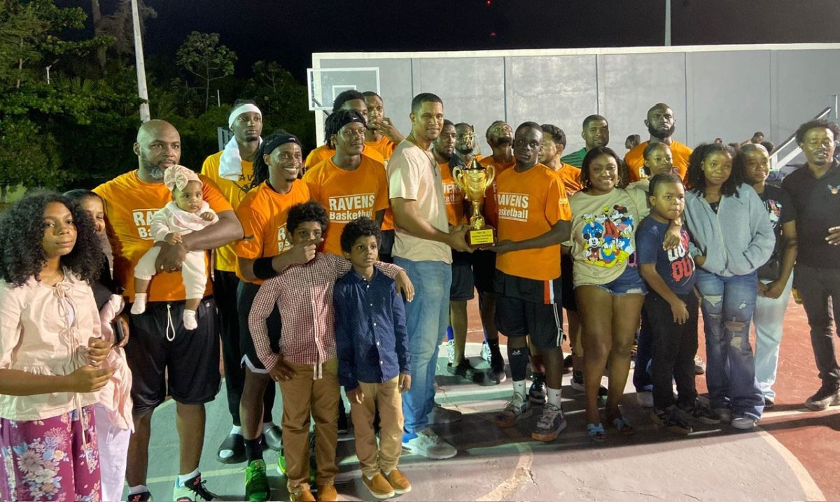 Ravens captain Shamar Huntley receives the championship trophy from Guyana Basketball Federation Vice-President and Georgetown Amateur Basketball Association President Jermaine Slater in the presence of his teammates and fans following the conclusion of the final.