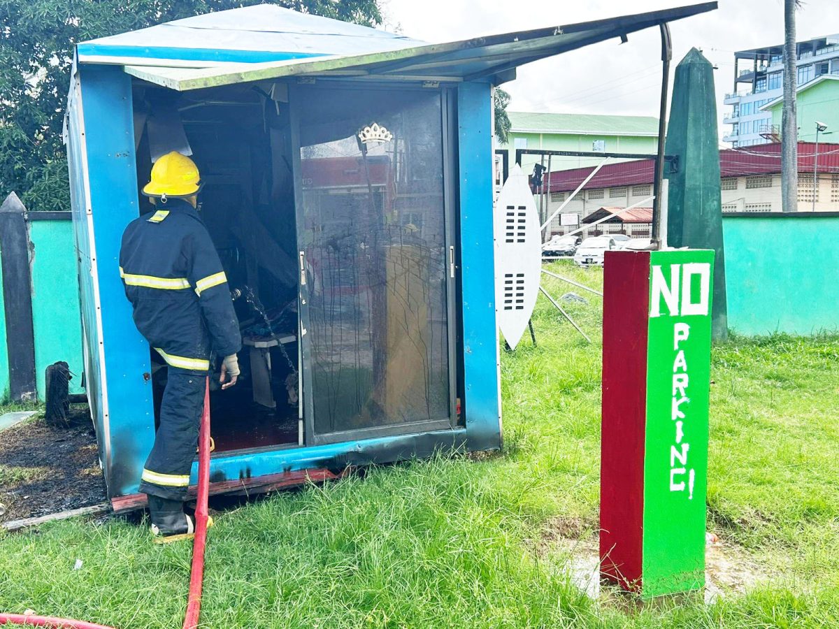 A firefighter giving the burnt area one last dousing of water
