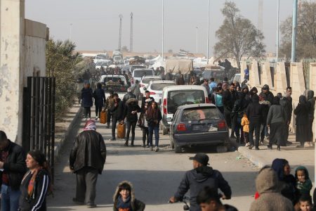 Displaced people who fled the Aleppo countryside walk past cars in Tabqa, Syria December 4, 2024. REUTERS/Orhan Qereman/File Photo 