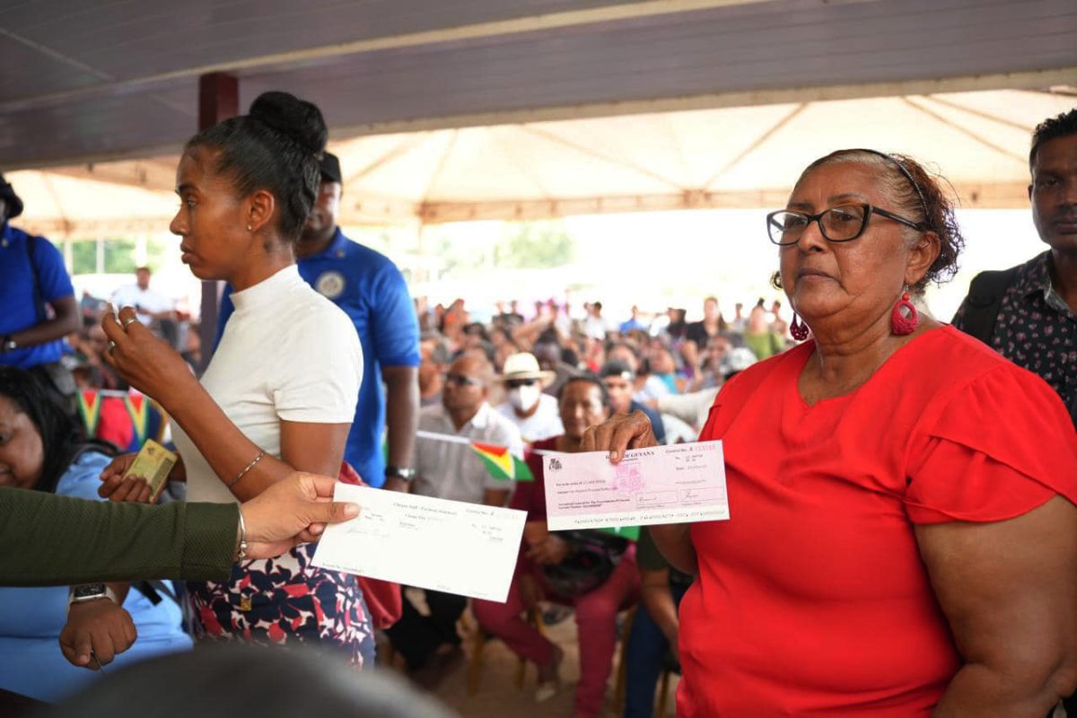 A resident from Region Nine with her cheque yesterday. (Office of the Prime Minister photo)