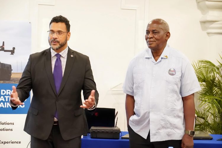 CANU Director James Singh (left) speaking at the training event. Home Affairs Minister Robeson Benn is at right. (Ministry of Home Affairs photo)