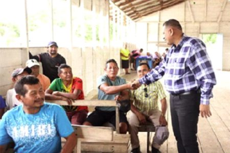 Minister Collin Croal (right) interacts with residents
