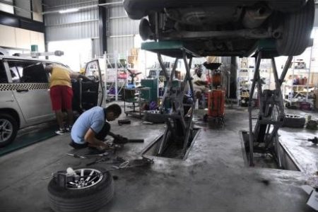A technician working on a vehicle at the WH Car Service repair shop in April.