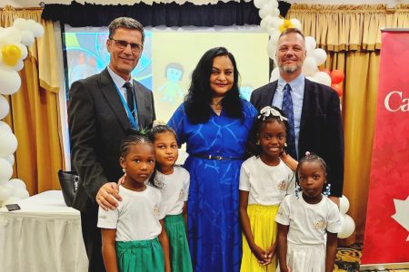 Minister of Human Services and Social Security Dr Vindhya Persaud (centre) with Deputy Head of Cooperation at the Canadian High Commission Adam Loyer (right), UNICEF representative Abdul Saleh (left), and children of the Jem West Daycare and Playgroup at the policy launch (Telesha Ramnarine photo)