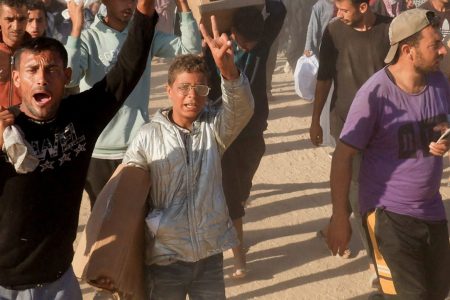 Palestinians carry aid supplies from the U.S.-backed Gaza Humanitarian Foundation, in Khan Younis, in the southern Gaza Strip, May 29, 2025. REUTERS/Hatem Khaled/File Photo 