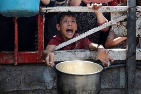 A Palestinian reacts as he waits to receive food from a charity kitchen, amid a hunger crisis, in Gaza City, July 28, 2025. REUTERS/Khamis Al-Rifi