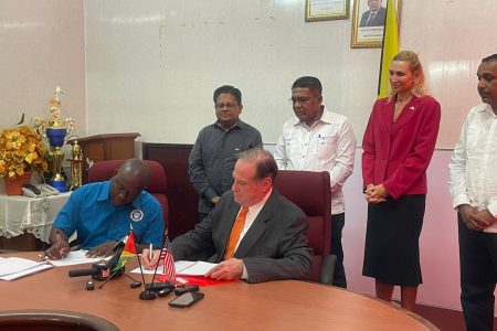 Chairman of Blumberg Grain, Philip Blumberg (right) signing the MoU. Standing from left are ministers Ashni Singh and Zulfikar Mustapha and US Ambassador Nicole Theriot. 